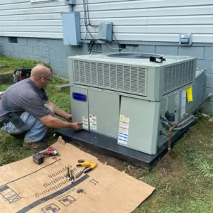 Hvac technian working on outside heat pump.